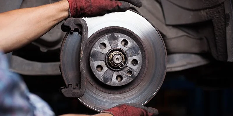 Close up shot of a Ford certified technician changing brakes on a Ford vehicle.
